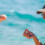 Mum and son playing on the beach with shells